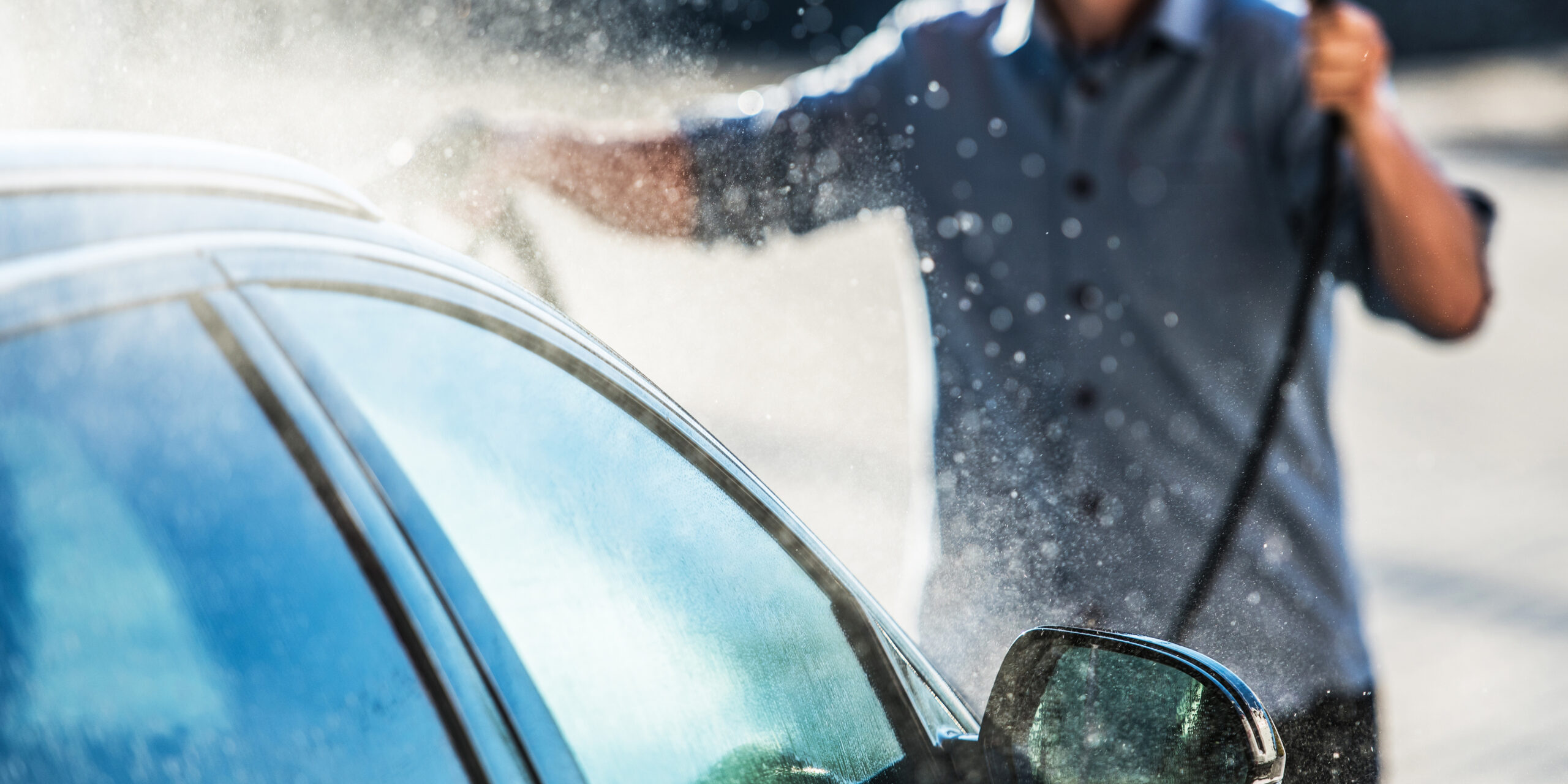 Un homme lave sa voiture dans une station de lavage de voiture Un homme lave sa voiture dans une station de lavage de voiture